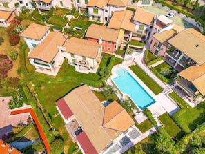 An aerial view of a residential area with houses, a swimming pool, and well-maintained gardens. - 640A Sonja's House (Torri del Benaco)