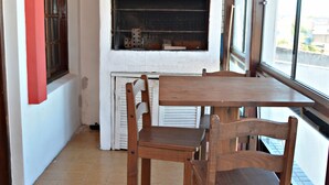 Une pièce avec une cheminée, des chaises en bois et une table.