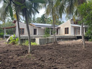 Ein zweistöckiges Haus mit Betonfundament, großen Fenstern und einem geneigten Dach.