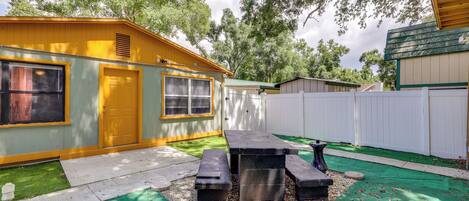 A mobile home with a patio area featuring a table and benches.
