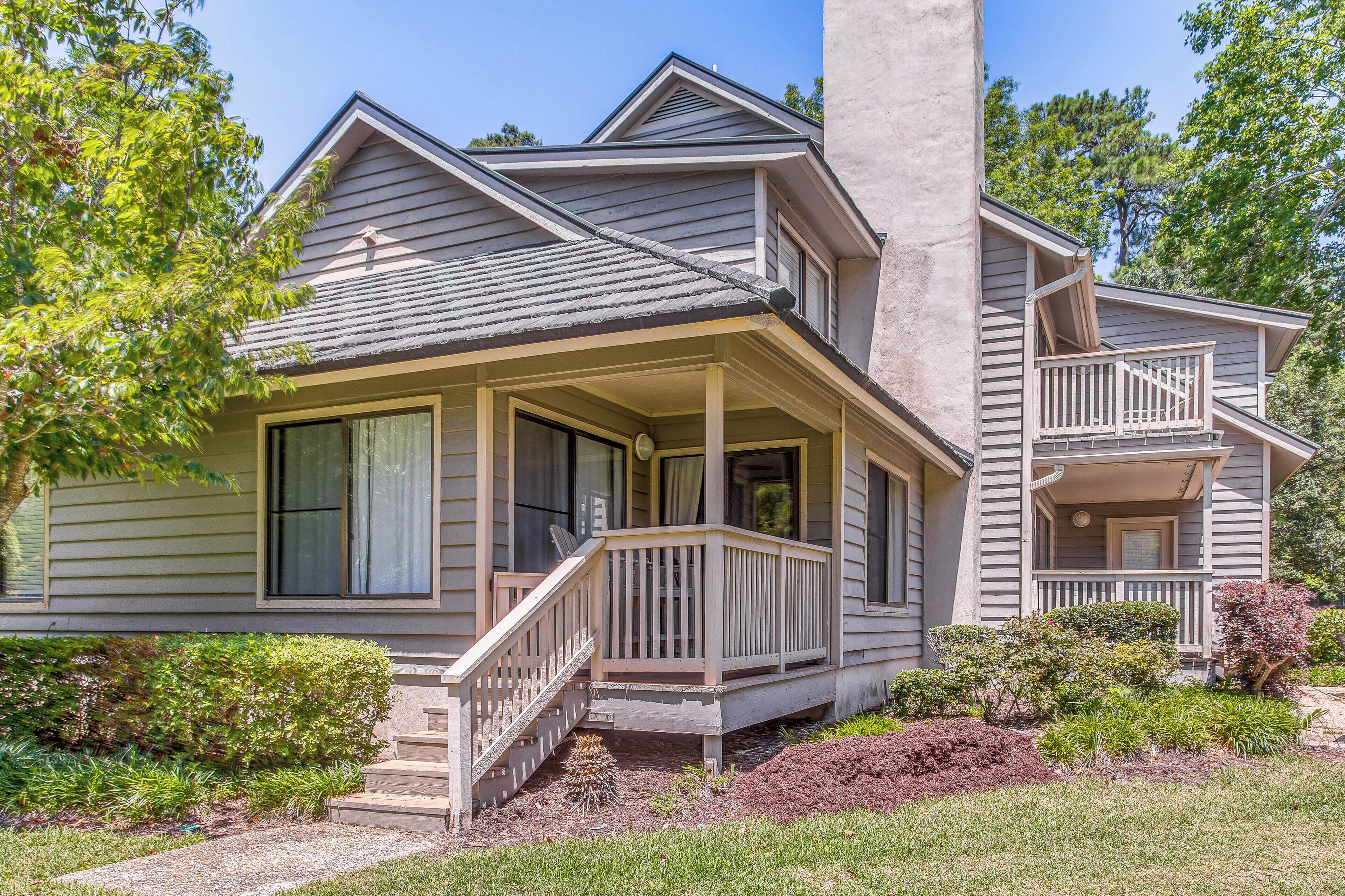 A two-story house with a porch, a chimney, and a well-maintained garden.