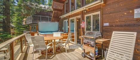 A wooden deck with outdoor furniture, a grill, and a pool.