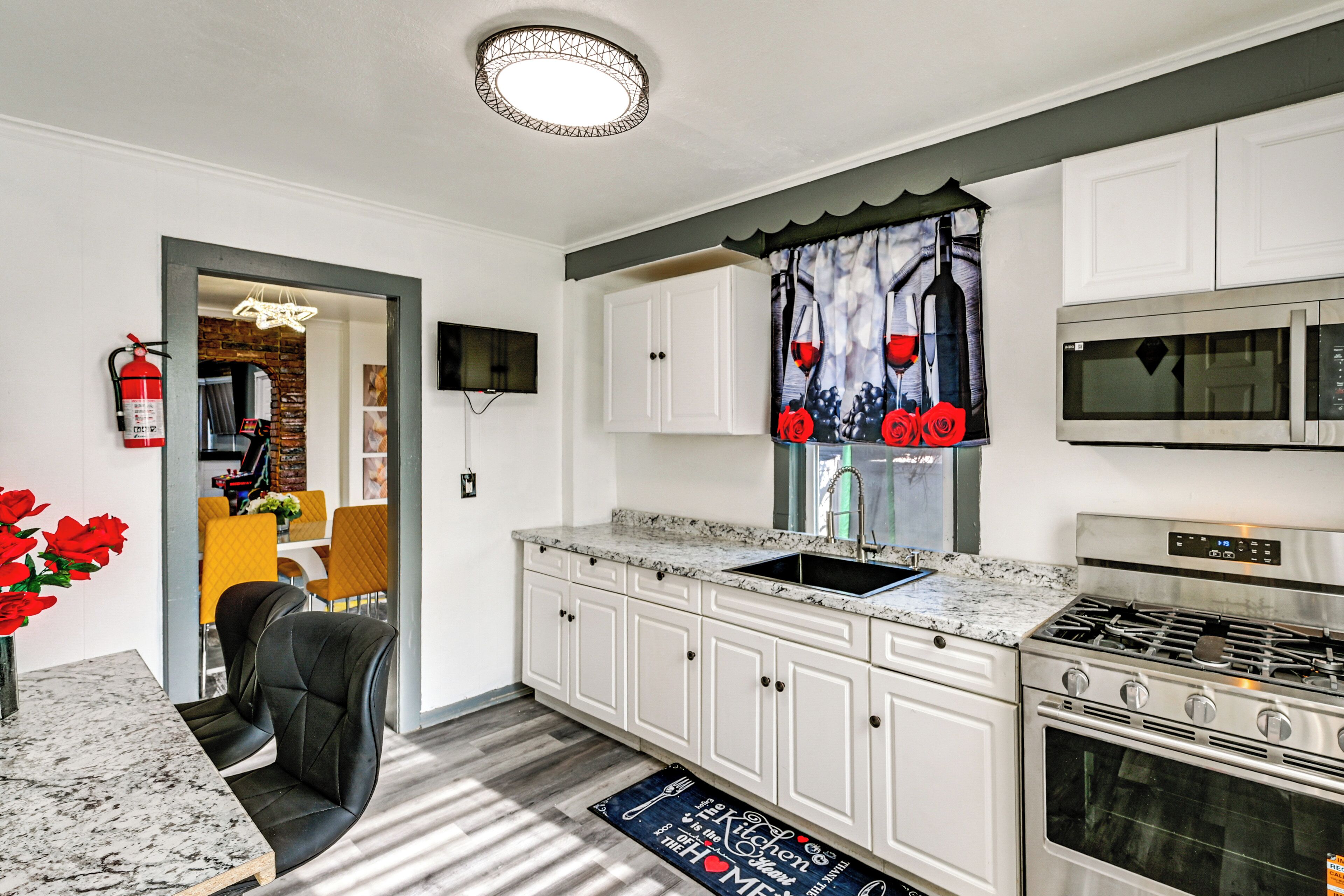 A modern kitchen with white cabinets, a stainless steel stove, and a microwave.