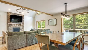 A modern living room with a stone fireplace, a large dining table, and a cozy sectional sofa. - 1 Mi to Beach! Home w/ Game Room in Albrightsville (Albrightsville)