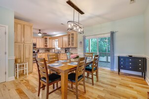 A kitchen with wooden cabinets, a dining table set for four, and a view to the outside.