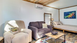 Una sala de estar acogedora con un sofá, un sillón y una mesita.