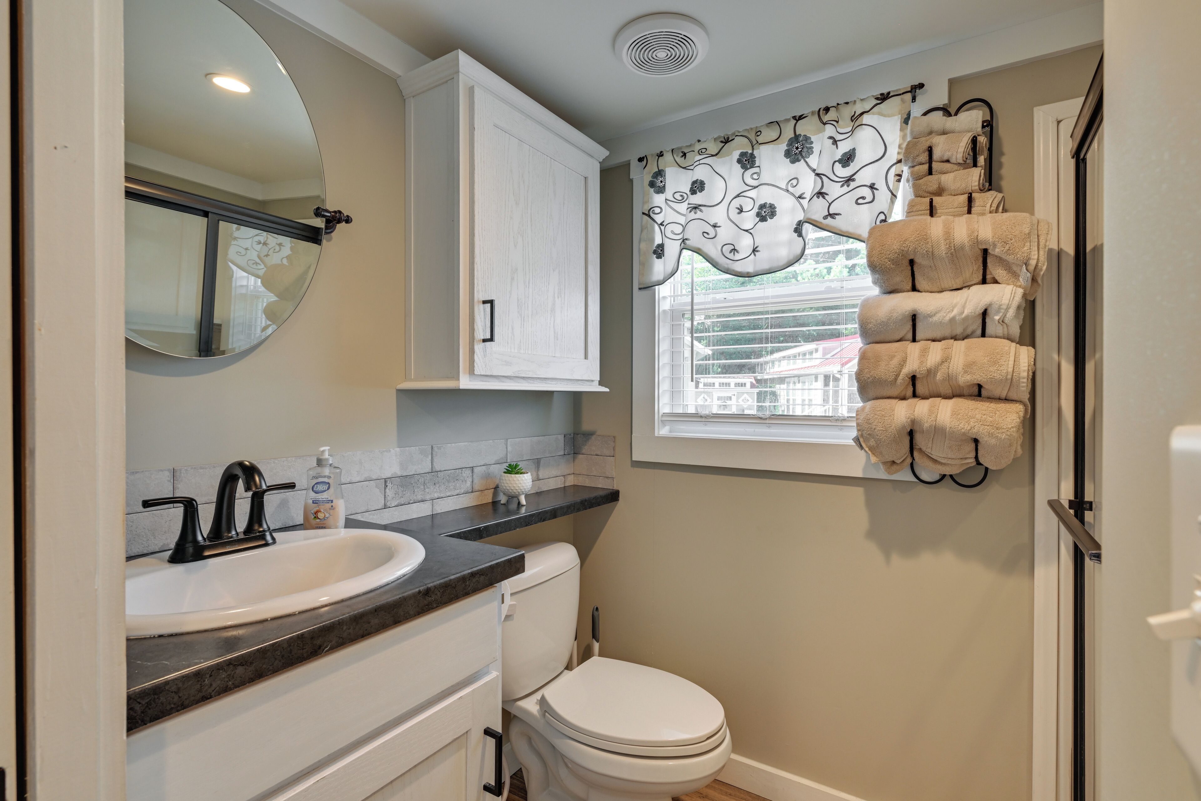 A bathroom with a sink, toilet, and a towel rack.