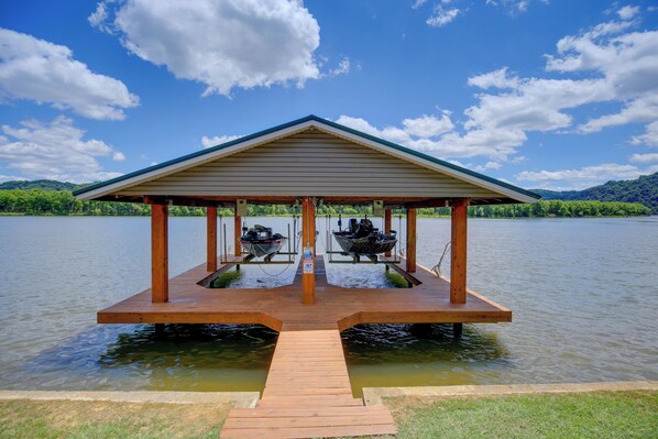A wooden dock with a covered pavilion over two boats, surrounded by water and greenery. - Boat, Fish, Swim! Draper Unit w/ Lake-view Deck (Draper)