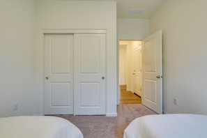 A bedroom with two beds, a closet, and a hallway leading to another room. - Modesto Area Family Getaway w/ Patio & Backyard! (Modesto)