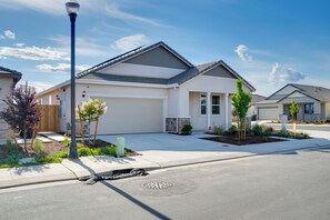 A residential house with a garage, a landscaped front yard, and a street lamp. - Modesto Area Family Getaway w/ Patio & Backyard! (Modesto)