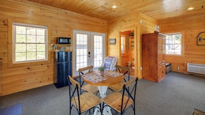 A wooden cabin interior with a dining table, chairs, a refrigerator, and a microwave. - Waterfront Deck w/ Mtn View! Claytor Lake Retreat (Draper)