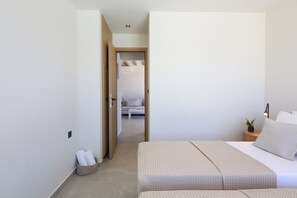 A modern bedroom with a bed, bedside table, and a small plant. - Villa Emanouill Nopigia (Nopigia)