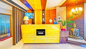 A reception desk with a sign reading 'TOWNHOUSE Company Serviced.' - Deluxe Indiranagar Leela Park Domlur (Bengaluru)