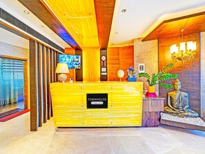 A reception desk with a sign reading 'TOWNHOUSE Company Serviced.' - Deluxe Indiranagar Leela Park Domlur (Bengaluru)