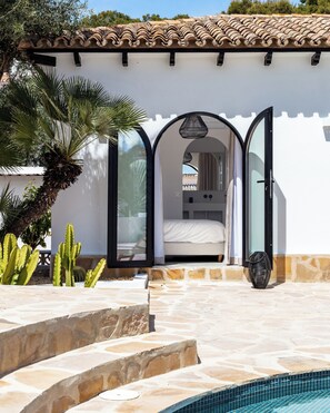A white building with a tiled roof, a pool, and a cactus plant. - Authentic hacienda near the Mediterranean Sea (VC)