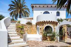 A white building with stone accents, a stone staircase, and a palm tree. - Authentic hacienda near the Mediterranean Sea (VC)