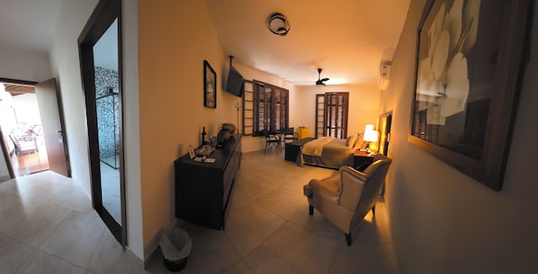 Ein Hotelzimmer mit Bett, Schreibtisch, Stuhl, Fernseher und Fenster.