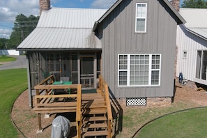 A two-story building with a covered porch, a chimney, and a small window. - Riverside Retreat with Walk-In Access and Gazebo (Heber Springs)