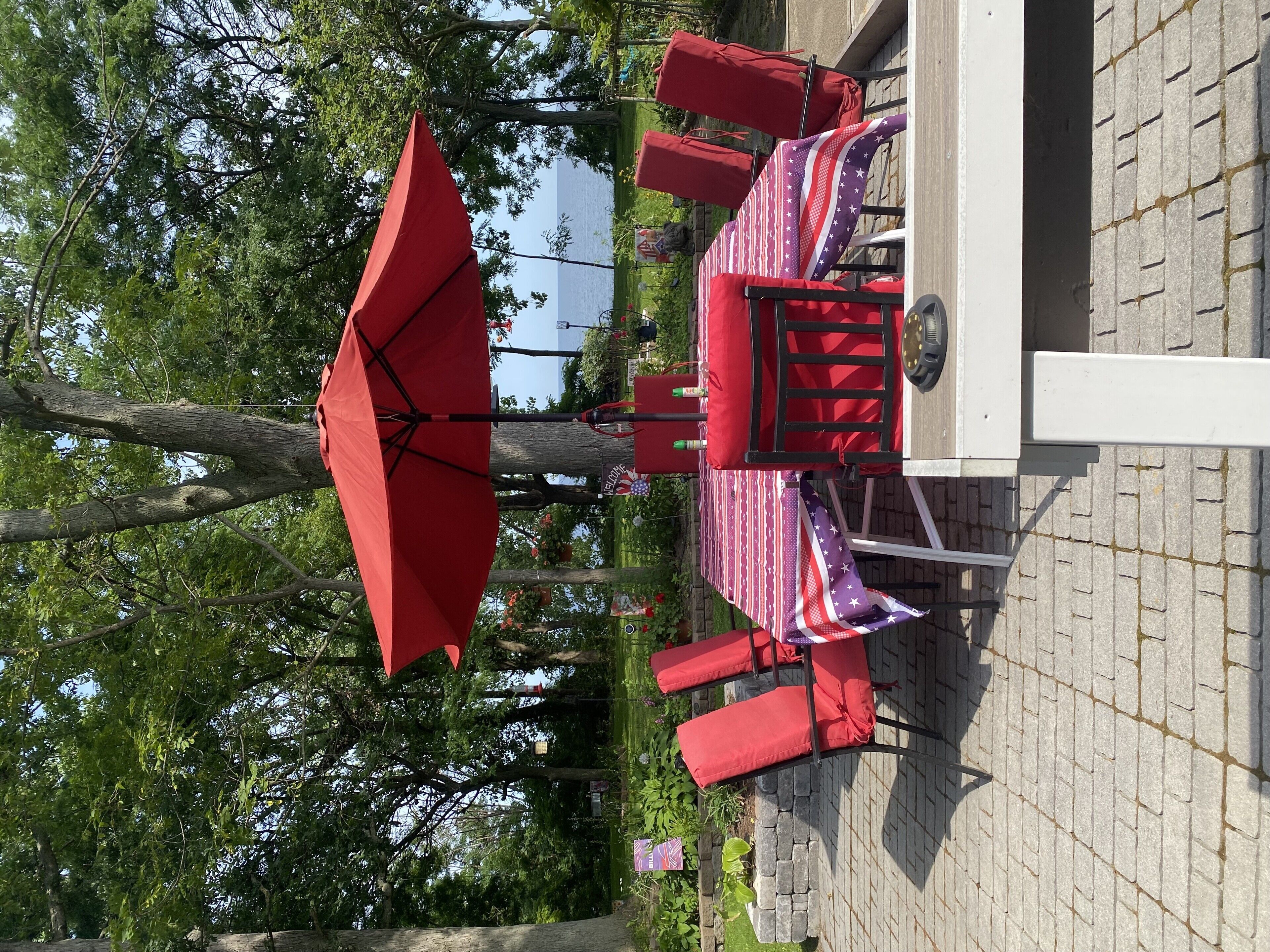 A patio area with a table and chairs, an umbrella, and a brick wall.