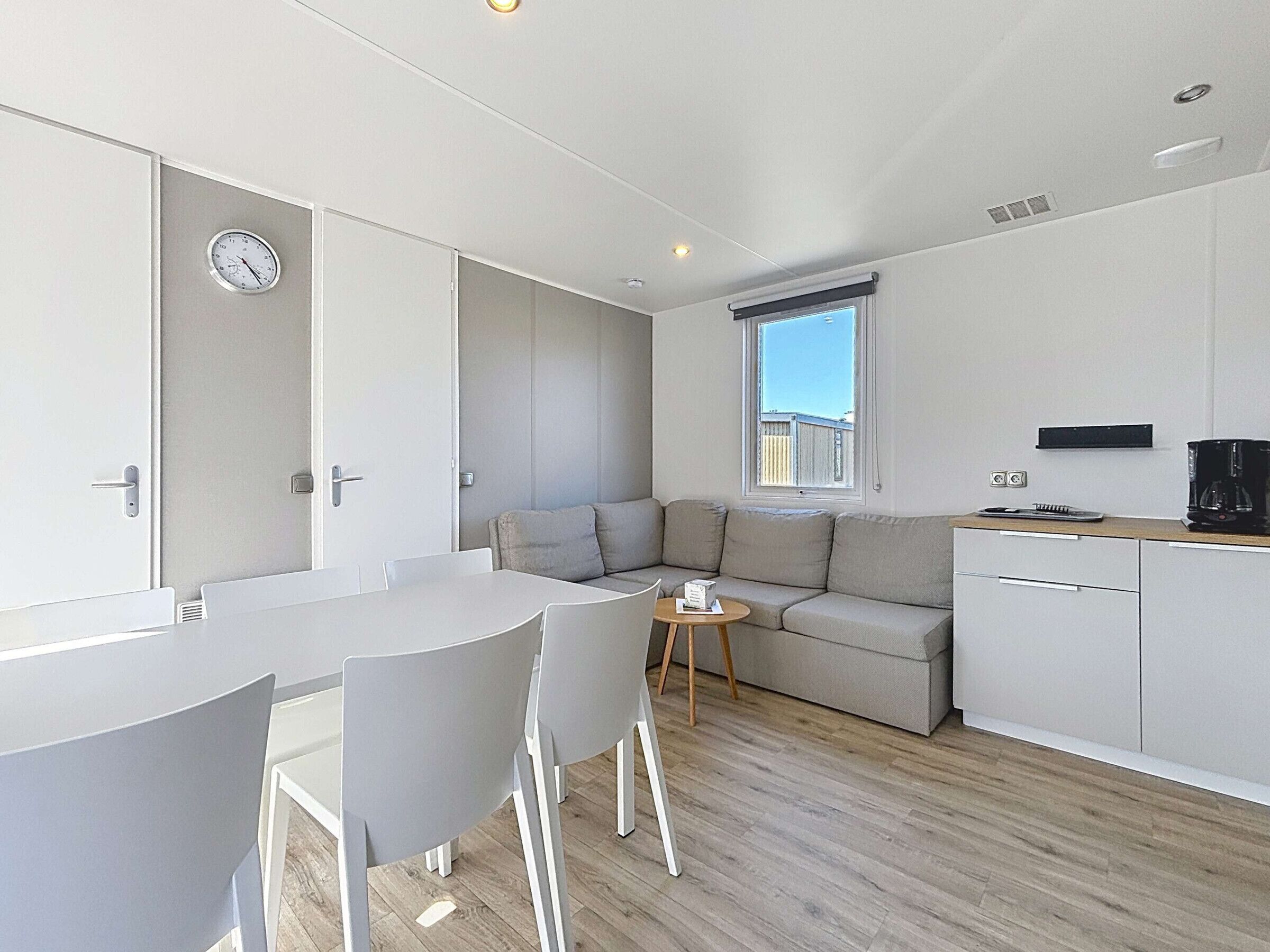Una cocina moderna con comedor, sofá y una pequeña mesa.