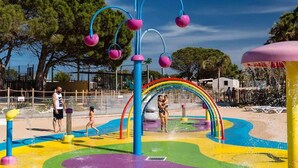 A water park with colorful play structures and a rainbow arch. - Mobile home with AC - 6 guests (Canet-en-Roussillon)