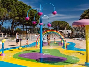 A water park with colorful play structures and a rainbow arch. - Mobile home with AC - 6 guests (Canet-en-Roussillon)