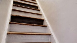 Un escalier avec des marches en bois et des murs blancs.