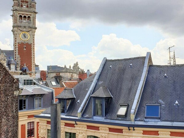 A historic building with a clock tower, steeply pitched roofs, and a mix of brick and stone facades.