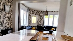 Une cuisine moderne avec un coin repas, un canapé et une grande fenêtre.