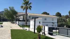 Une maison moderne à deux étages, dotée d’un toit en tuiles, d’une allée pavée et d’une pelouse bien entretenue.