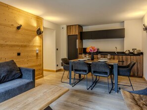 Ett modernt kök med matplats, träpanel och en soffa.