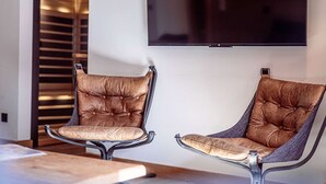 Two leather armchairs with metal frames, a wooden floor, and a flat-screen TV mounted on the wall. - Luxury apartment in center - 6 guests (Belle Plagne)