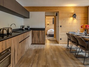 Una cocina moderna con armarios de madera y un comedor con mesa y sillas de madera.