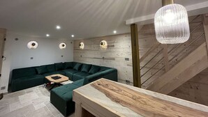 Een moderne woonkamer met een modulaire bank, een houten salontafel en een trap.