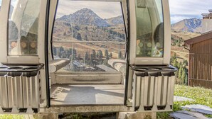 Een voertuig met uitzicht op een bergachtig landschap door de open deur.