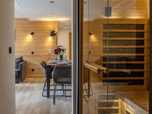A modern interior with a dining area, a sofa, and a staircase. - Cozy apartment - 6 guests, near slopes (Belle Plagne)