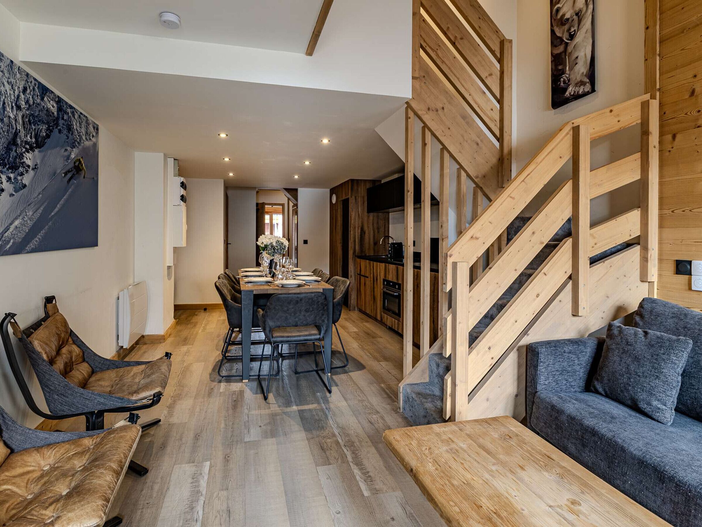 A modern interior with a dining area, a staircase, and a living room.