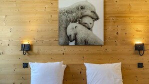 A wooden wall with a picture of polar bears, two white pillows, and two wall-mounted light fixtures. - Cozy apartment in Belle Plagne - 6 guests (Belle Plagne)