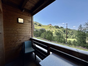Eine Holzhütte mit einem Balkon mit Blick auf eine gebirgige Landschaft.