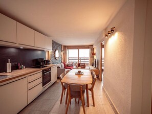 Una cocina compacta con comedor, muebles de madera y una pared de acento de piedra.