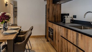Een moderne keuken met houten kastjes, een zwart aanrecht en een roestvrijstalen spoelbak.