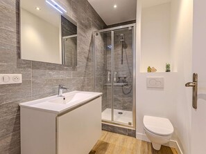 A modern bathroom with a glass shower enclosure, a white sink, and a toilet. - Convenient apartment in Plagne 1800 - 6 guests (La Plagne 1800)