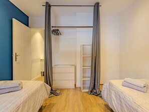 A bedroom with two beds, a wardrobe, and a hanging rack. - Convenient apartment in Plagne 1800 - 6 guests (La Plagne 1800)
