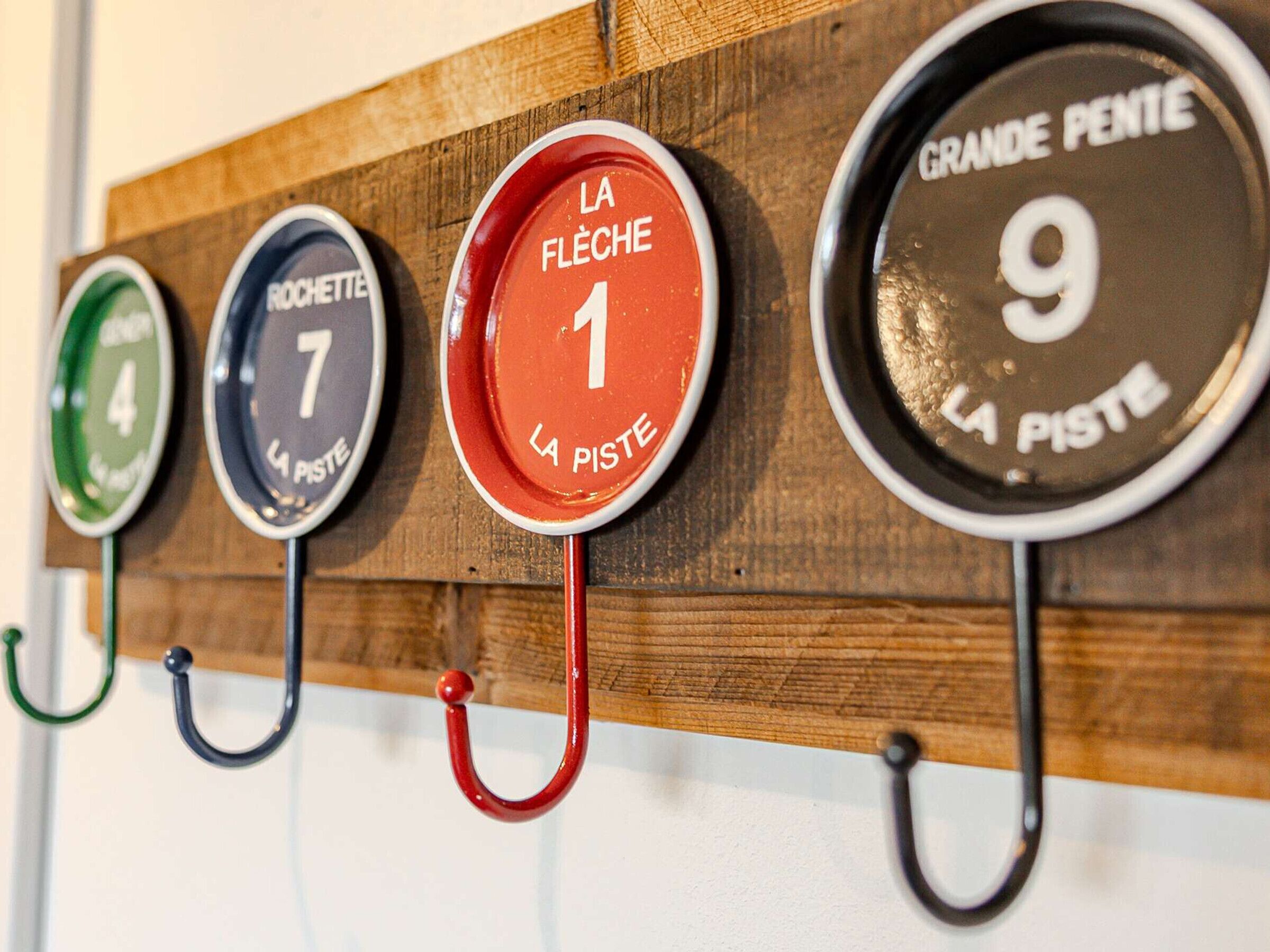 A wall-mounted rack with numbered hooks labeled 'LA PISTE' and 'GRANDE PENTE'.