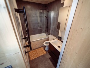 A bathroom with a shower, toilet, sink, and wooden flooring. - Stunning apartment, panoramic view - 6 guests (Plagne Aime 2000)