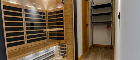 Ein begehbarer Kleiderschrank mit Holzböden und einer spiegelnden Schranktür.