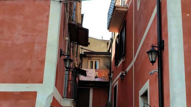 Une ruelle étroite avec un escalier menant à l’entrée d’un immeuble.