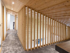 Ein Zimmer mit schrägen Deckenbalken und Teppichboden.