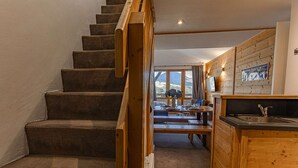 Una escalera de madera que conduce a un comedor con vistas a las montañas.