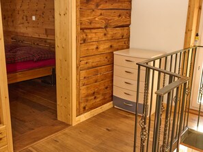 Ein Zimmer mit Holzeinrichtung, einem Bett, einem Schminktisch und einer Treppe.